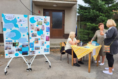 Nástěnka naší školy a paní u vstupu na akci.