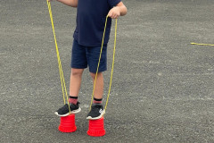 Chlapec na dětských chůdách z kyblíků.