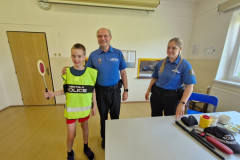 Chlapec v policejní vestě s plácačkou.