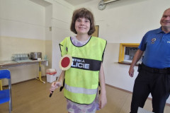 Dívka v policejní vestě s plácačkou.