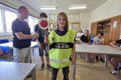 Chlapec v policejní vestě s plácačkou.