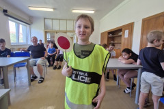 Chlapec v policejní vestě s plácačkou.