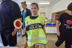 Dívka v policejní vestě s plácačkou.