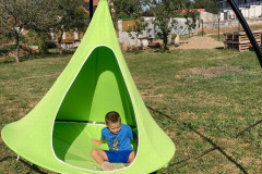 Chlapec venku v závěsné houpačce.