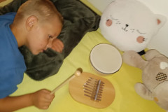 Chlapec ve snoezelenu hraje na etnické nástroje,