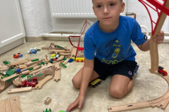 Chlapec si hraje s vláčko dráhou.