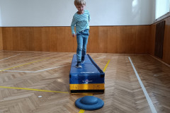 Chlapec na překážkové dráze v tělocvičně.
