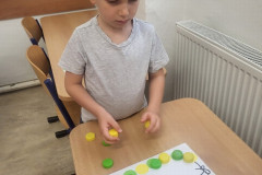 Chlapec pracuje s barevnými vršky.