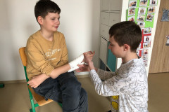 Chlapci si zkouší první pomoc při poranění ruky.