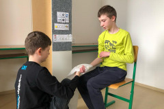 Chlapci si zkouší první pomoc při poranění ruky.