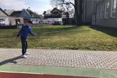 Chlapec skáče panáka na školním hřišti.