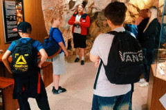 Žáci koukají na výstavku v jeskyních.