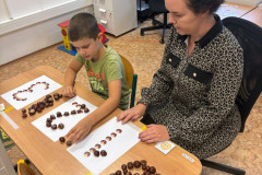 Chlapec pracuje v lavici s paní učitelkou.