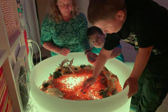 Žáci ve snoezelenu s přírodninami.