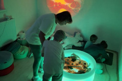 Žáci ve snoezelenu s přírodninami.