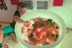 Žáci ve snoezelenu s přírodninami.