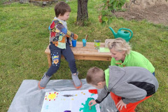 Žáci venku malují společný obraz.