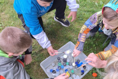 Žáci loví víčka z vody.