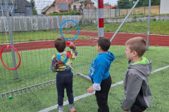 Chlapec trefuje míčky obruč.