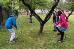 Žáci u zavěšených kruhů v jabloňovém sadu.