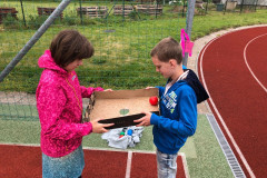 Žáci se společně snaží dostat v krabici míček do díry.