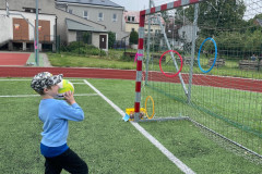 Chlapec trefuje míčem zavěšenou obruč.