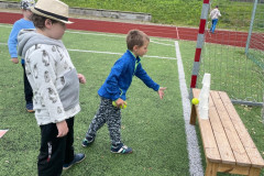 Chlapec hází míček na pyramidu z kelímků.