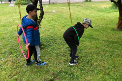 Žáci u zavěšených kruhů v jabloňovém sadu.