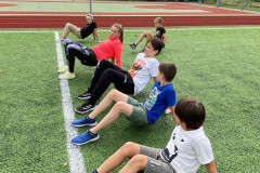 Třída cvičí venku na hřišti.