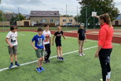 Třída poskakuje na čáře venku na hřišti.