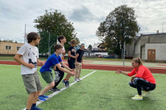 Třída poskakuje na čáře venku na hřišti.