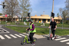 Dívka a pan asistent na koloběžkách  na dopravním hřišti.