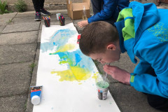 Chlapec fouká barevné bubliny na výkres.