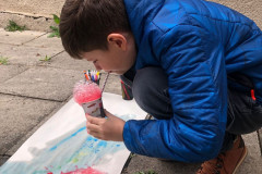 Chlapec fouká barevné bubliny na výkres.