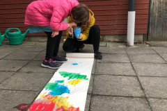 Dívka fouká barevné bubliny na výkres.