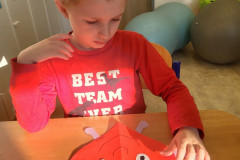 Chlapec v červené pracuje v lavici.