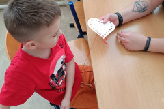 Chlapec v červené pracuje u lavice.