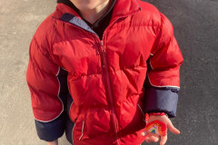 Chlapec venku s malovaným kamínkem.