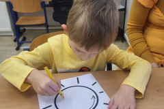 Chlapec ve žluté pracuje v lavici.