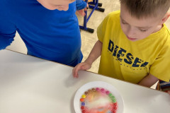 Žáci při duhovém pokusu s lentilkama.