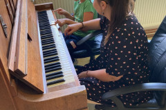 Chlapec s paní učitelkou hrají na klavír.