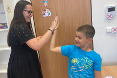 Chlapec si dává placáka s paní učitelkou.