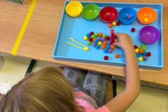 Dívka trénuje jemnou motoriku a třídění barev.