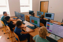 Žáci pracují na počítačích.