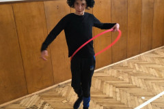 Chlapec v kostýmu v tělocvičně s obručí.