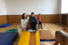 Chlapec s paní asistentkou v kostýmu v tělocvičně na překážkové dráze.