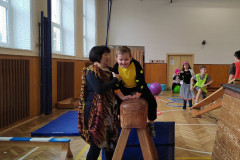 Chlapec s paní asistentkou v kostýmu v tělocvičně na překážkové dráze.