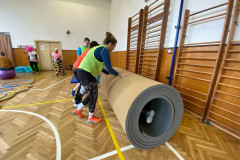 Žáci v kostýmech  v tělocvičně na překážkové dráze.