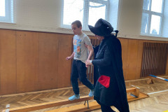 Chlapec s paní asistentkou v kostýmu v tělocvičně na překážkové dráze.