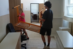 Lidé nosí nábytek do tříd.